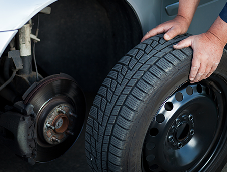 Person Placing Tire on Car